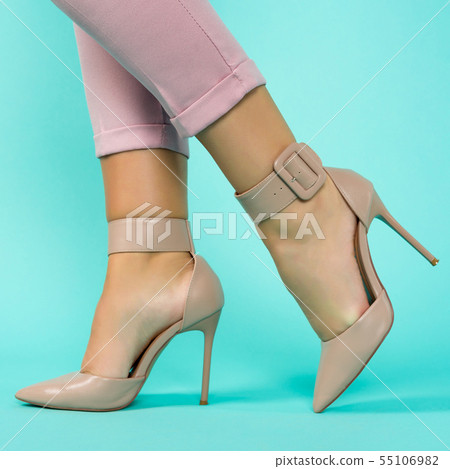 Sexy legs in brown high heels shoes on blue Sexy legs in brown high heels shoes on blue 55106982
