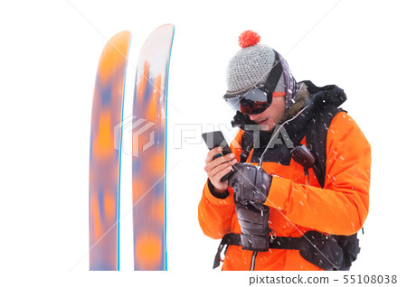 Portrait of a professional athlete skier with a cell phone in his hands next to skis isolated on Portrait of a professional athlete skier with a cell phone in his hands next to skis isolated on 55108038