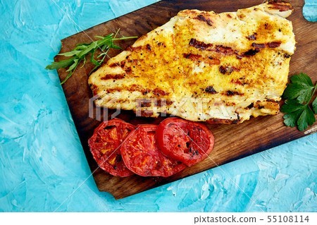 Grilled pike fillet with tomatoes on wooden board Grilled pike fillet with tomatoes on wooden board 55108114