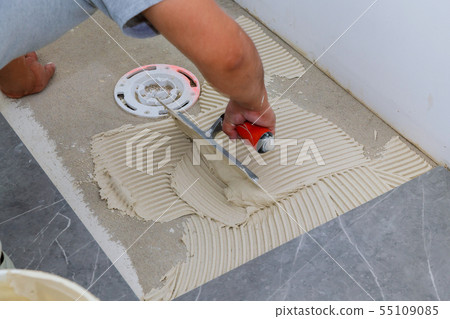 Troweling mortar onto a concrete floor in Troweling mortar onto a concrete floor in 55109085