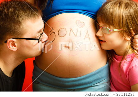 Father and daughter kissing pregnant mother 55111255