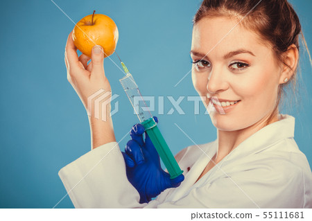 Scientist doctor injecting apple. GM Food. 55111681