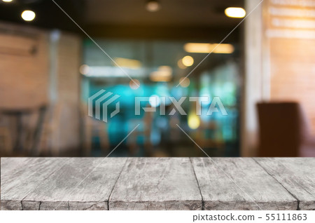 empty wooden desk over blurred coffee shop 55111863