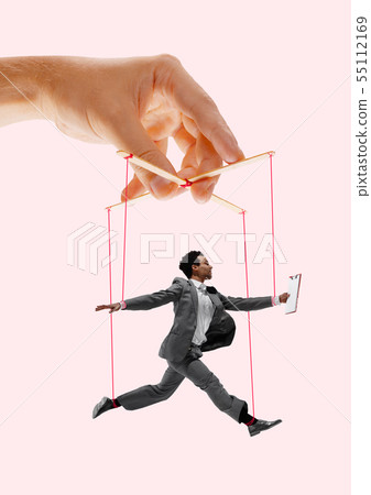 Man like a puppet in somebodies hands. Concept of manipulation Man like a puppet in somebodies hands. Concept of manipulation 55112169
