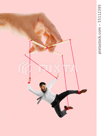 Man like a puppet in somebodies hands. Concept of manipulation Man like a puppet in somebodies hands. Concept of manipulation 55112395