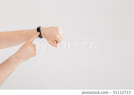 Fitness and technology concept - Activity tracker on a male wrist on white background with copy 55112713