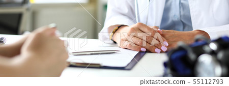 Therapeutist in clinic receiving sick visitor discussing health complaints 55112793