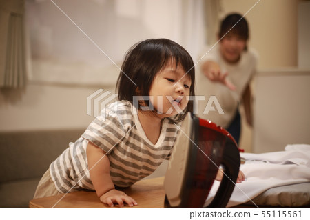 Girl trying to touch the iron 55115561