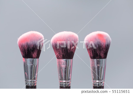 Powder brushes on light background with pink powder splash close up 55115651