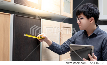 Man choosing cabinet material in furniture store Man choosing cabinet material in furniture store 55116135