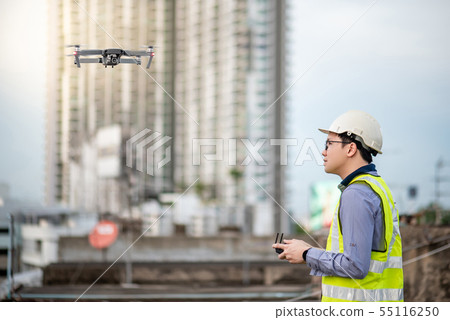 Asian engineer flying drone over construction site 55116250