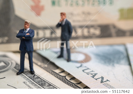 Figure businessman standing on US dollar and YUAN Figure businessman standing on US dollar and YUAN 55117642