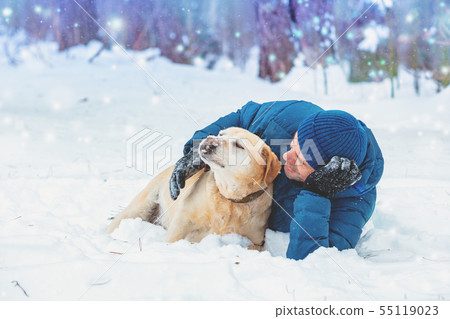 A happy man with a Labrador retriever dog lying in A happy man with a Labrador retriever dog lying in 55119023