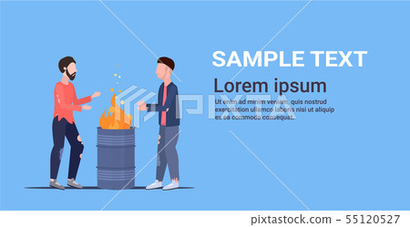 two poor men warming by fire beggars standing near burning garbage in barrel homeless jobless 55120527