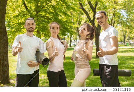 Four friends satisfied of successful training outdoors showing thumbs up 55121316