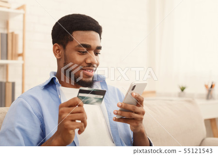 Man holding credit card and using smartphone for online shopping Man holding credit card and using smartphone for online shopping 55121543