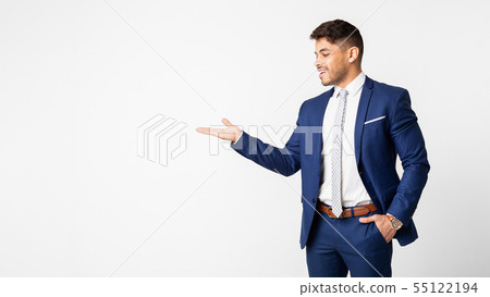 Smiling Businessman Presenting Something On Empty Palm Over White Background 55122194