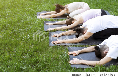 Group of people lying on yoga mats making Child pose 55122195