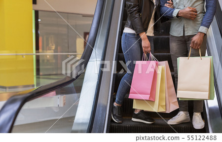 African couple with shopping bags going down the escalator 55122488