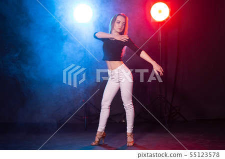 Nightlife and club concept - young woman dancing in the dark under the lights 55123578