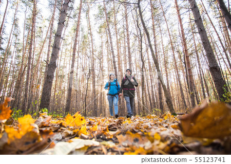 adventure, travel, tourism, hike and people concept - smiling couple walking with backpacks over adventure, travel, tourism, hike and people concept - smiling couple walking with backpacks over 55123741
