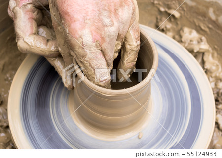 potter's hands mold pottery on a rotating wheel 55124933