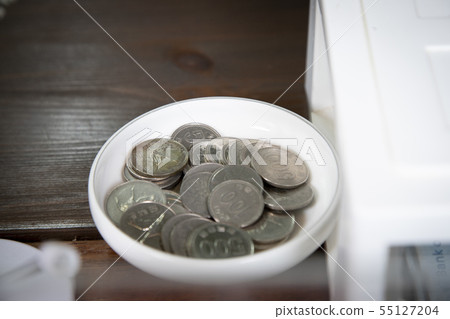 Coins on a white plate 55127204