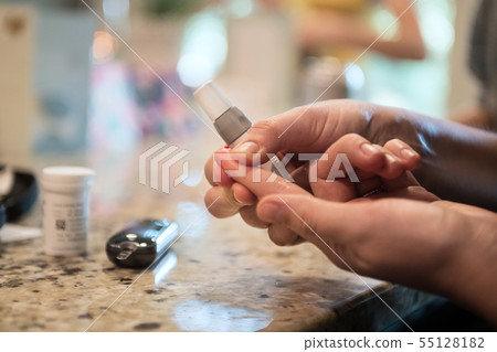 Woman using diabetes blood test 55128182