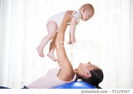 Mother lifting her baby Mother lifting her baby 55129567