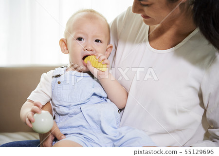 Little boy eating apple slice 55129696