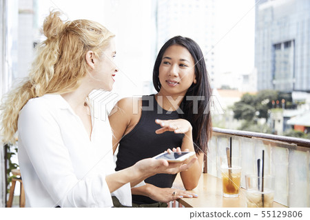 Female friends on cafe balcony Female friends on cafe balcony 55129806