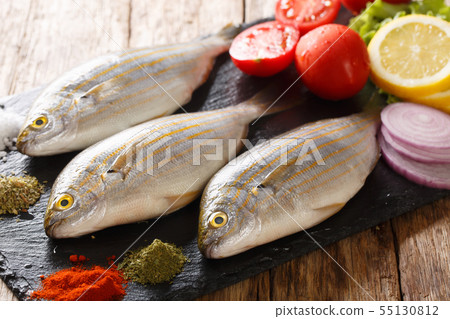Raw Sarpa salpa with ingredients close-up on a Raw Sarpa salpa with ingredients close-up on a 55130812