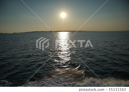在地平線的日落波浪和雄偉的看法從海的日落 在地平線的日落波浪和雄偉的看法從海的日落 55131583