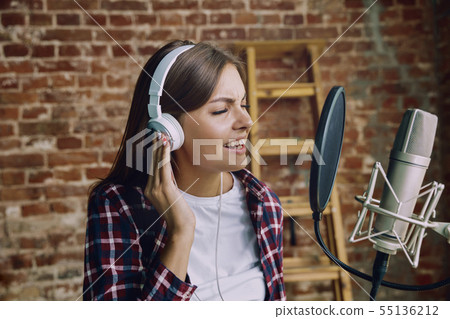 Woman recording music, broadcasting and singing at home Woman recording music, broadcasting and singing at home 55136212
