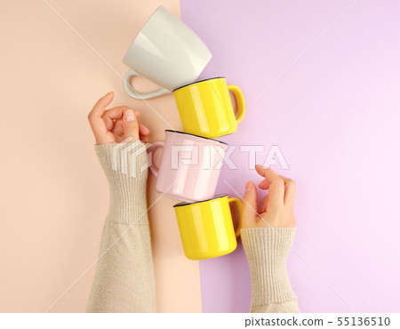 stack ceramic cups are supported by a female hand 55136510