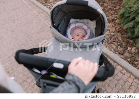 Mother strolling with newborn outside. Mother's hands. First person view Mother strolling with newborn outside. Mother's hands. First person view 55136958
