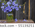 Bouquet of Chicory flowers in vase on wooden table 55139251