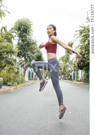 Woman jumping to warm up Woman jumping to warm up 55139777