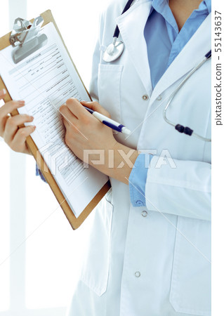 Female doctor using medical form on clipboard closeup. Physicianat work in hospital or clinic Female doctor using medical form on clipboard closeup. Physicianat work in hospital or clinic 55143637