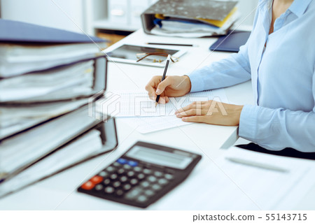 Unknown female bookkeeper or financial inspector calculating or checking balance, making report Unknown female bookkeeper or financial inspector calculating or checking balance, making report 55143715