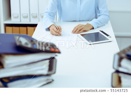 Unknown female bookkeeper or financial inspector calculating or checking balance, making report Unknown female bookkeeper or financial inspector calculating or checking balance, making report 55143725