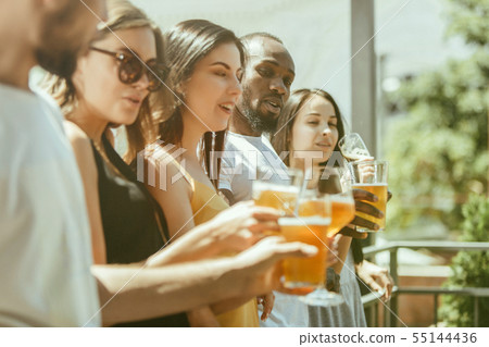 Young group of friends drinking beer and celebrating together Young group of friends drinking beer and celebrating together 55144436