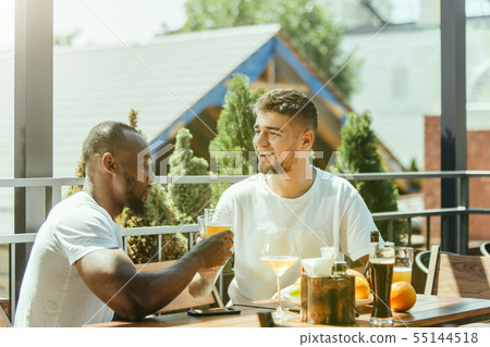 Young men drinking beer and celebrating together Young men drinking beer and celebrating together 55144518