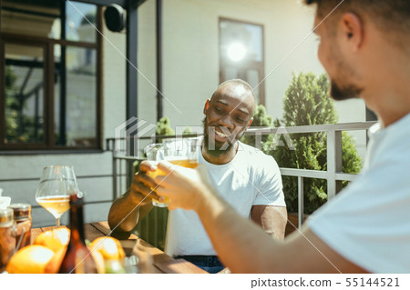 Young men drinking beer and celebrating together 55144521