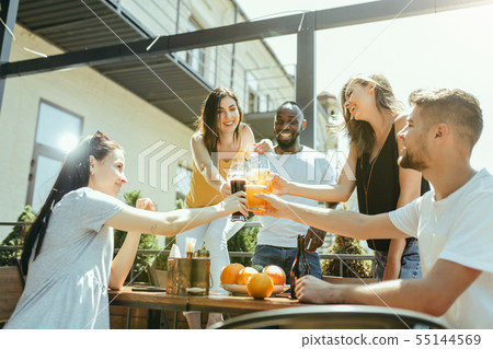 Young group of friends drinking beer and celebrating together Young group of friends drinking beer and celebrating together 55144569