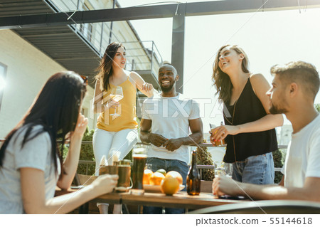 Young group of friends drinking beer and celebrating together Young group of friends drinking beer and celebrating together 55144618