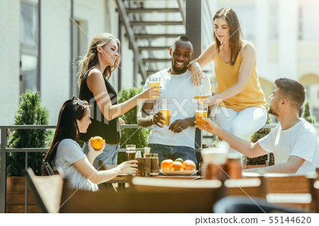 Young group of friends drinking beer and celebrating together Young group of friends drinking beer and celebrating together 55144620