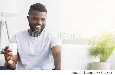 Young man using laptop, having video chat Young man using laptop, having video chat 55147374