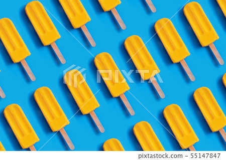Pattern made of bright yellow mango ice cream on blue pastel background. 55147847