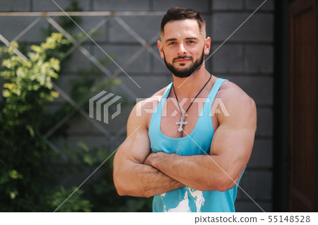 Handsome bodybuilder in blue singlet posing outside. Bearden men before training 55148528